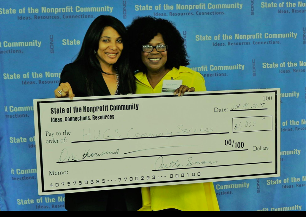 Aretha Simons presenting a grant check to HUGS Community Services